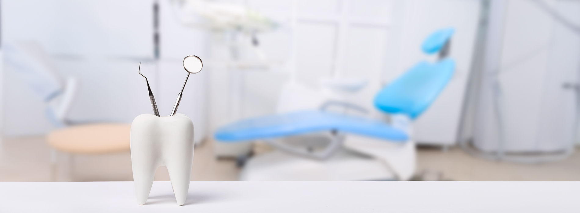 The image features a modern, minimalist dental office with a blue chair and a white desk in the foreground, set against a backdrop of a clean, bright room.