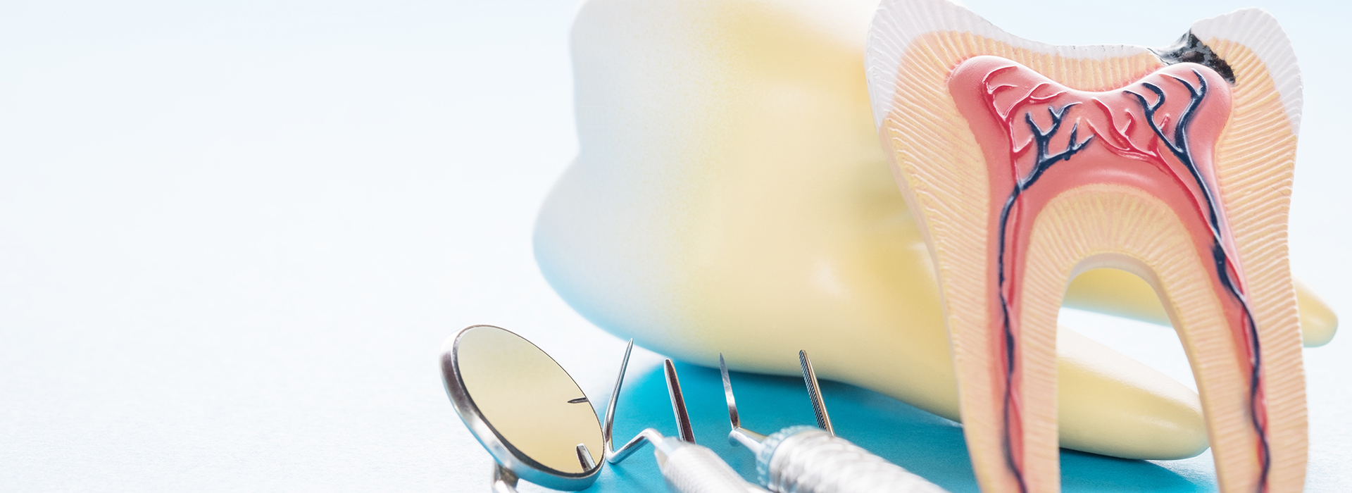 The image shows a close-up of dental tools, including a toothbrush and a dental mirror, with a colorful illustration of teeth and gums in the background.