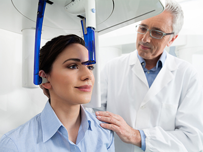 A person receiving a medical procedure in a modern clinic, with a doctor standing by, overseeing the treatment.