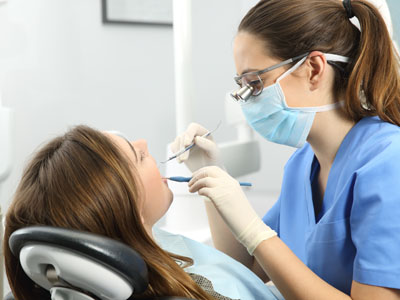 The image features a dental professional providing care to a patient in a clinical setting.