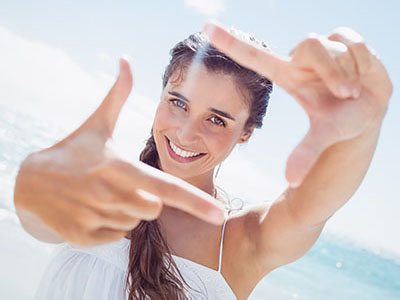 A woman is taking a selfie with her finger pointing at the camera.